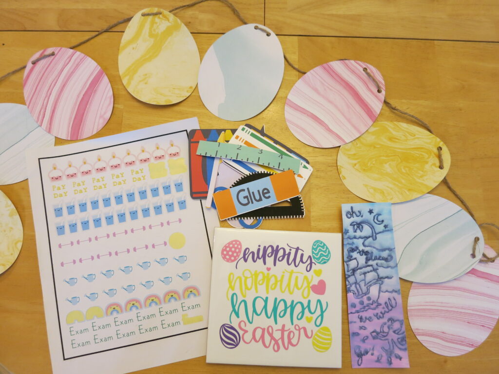 A marbled egg banner. A sheet of stickers for a planner. School supply magnets. "Oh the places we will go" nautical bookmark. "Hippity Hoppity Happy Easter" trivet in pastel colours. 