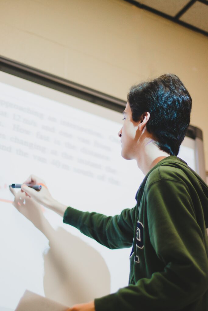 A person using a pen on a SMART board.